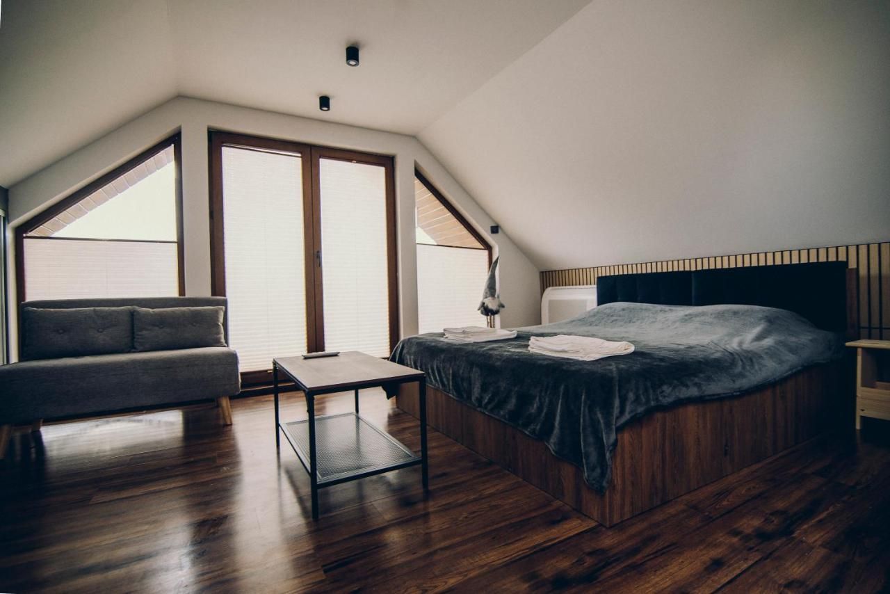 Jasna sypialnia na poddaszu z wyjściem na balkon